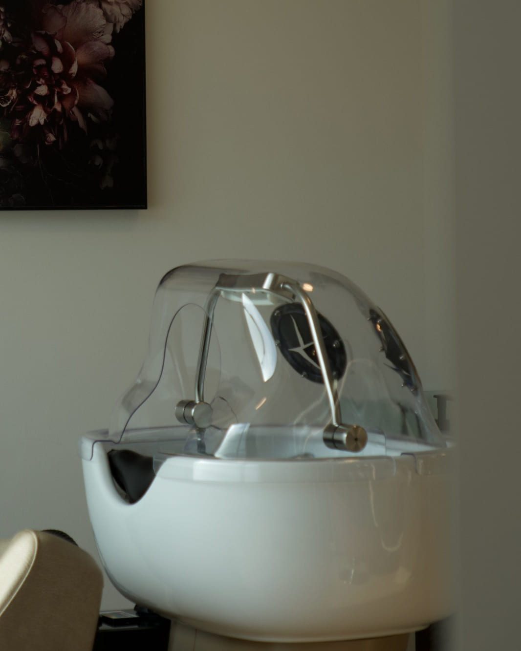 Head-Spa-Waschschale mit transparenter Haube, im Hintergrund ein Blumenporträt